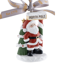 Load image into Gallery viewer, Santa Claus figurine with a 'North Pole' sign and a ribbon on a white background