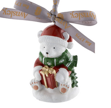 Load image into Gallery viewer, Christmas-themed figurine of a polar bear with a gift and Santa hat, tied with a ribbon, on a white background.
