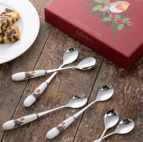 Set of decorative spoons with a matching box on a wooden surface