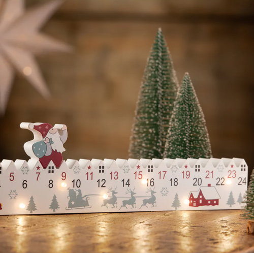 Wooden advent calendar with Christmas-themed designs on a wooden surface.