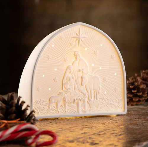Decorative night light with nativity scene design on a wooden surface.